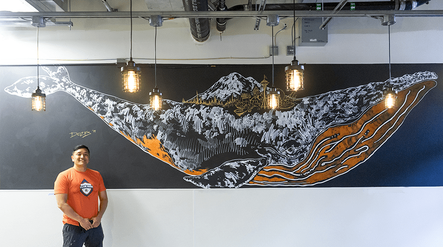 Dozfy poses in front of his mural of a whale