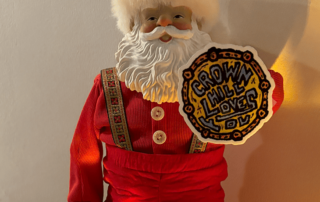 Santa doll holds a crown hill loves you sticker.